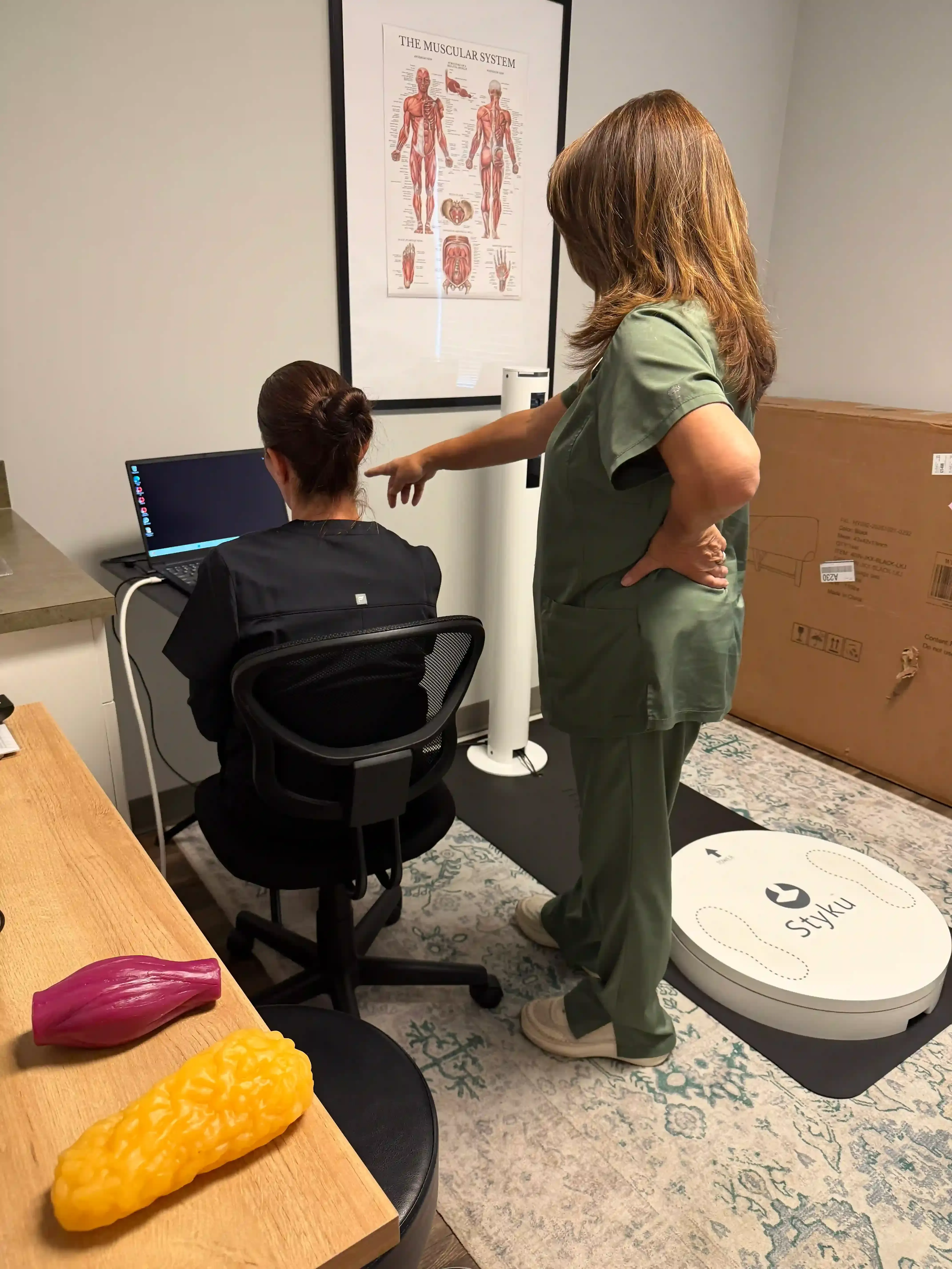 Aspire Trim Clinic coach and client comparing two Styku body composition scans at a check-in in Matthews, NC